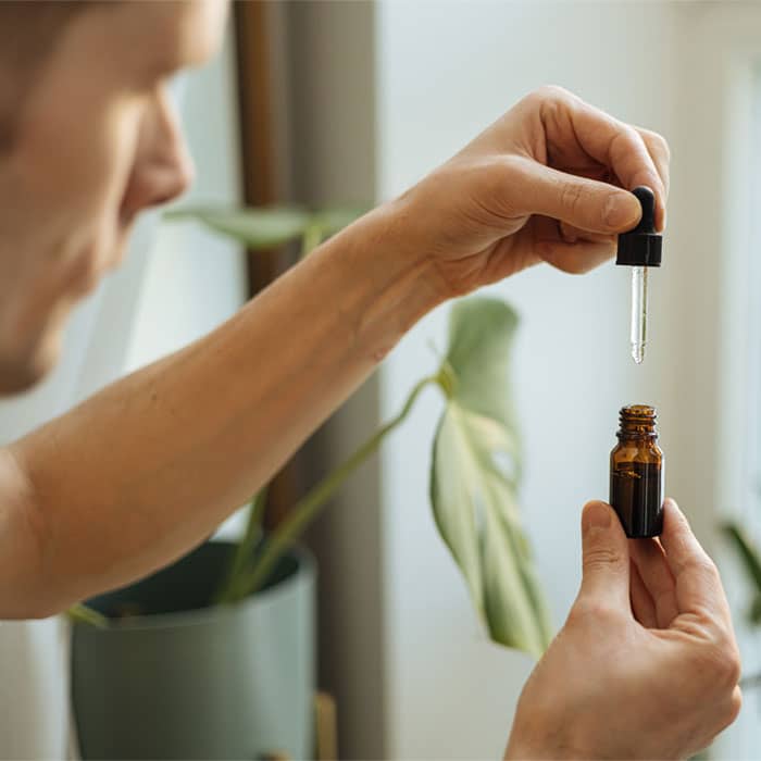 Hand holding a pipette of oil