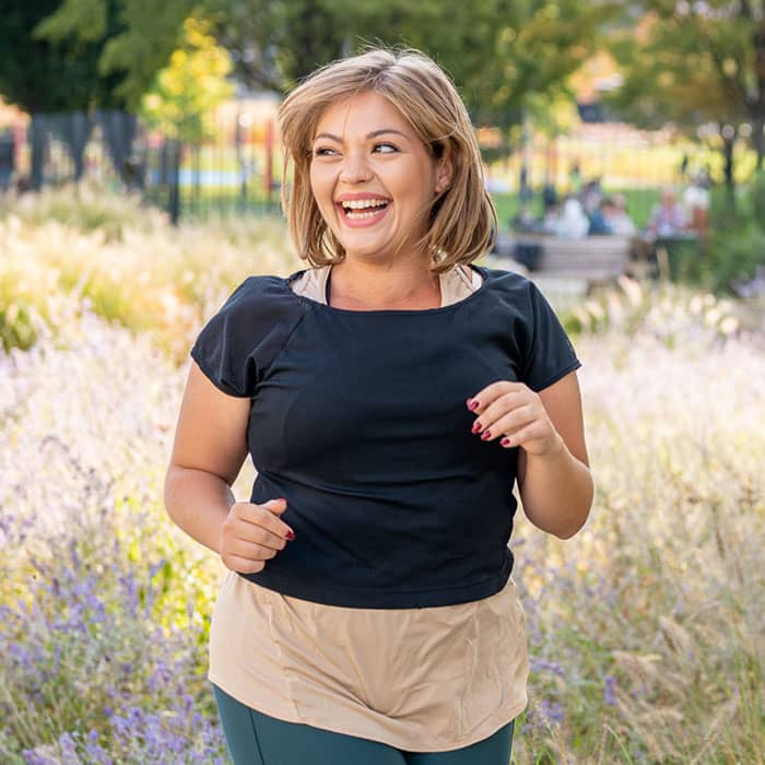 Positive, sporty woman jogging outdoors