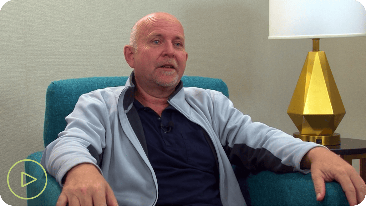 older man sitting in blue chair with gold lamp