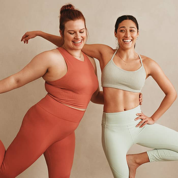 two women in athletic wear smiling